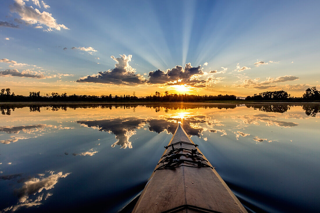 Kajakfahren in die Sonnenstrahlen auf McWennger Slough in der Nähe von Kalispell, Montana, USA