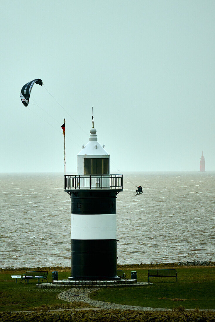 Ein Kitesurfer umrundet den Leuchtturm "Kleiner Preuße" in Wremen, Landkreis Cuxhaven, Niedersachsen, Deutschland