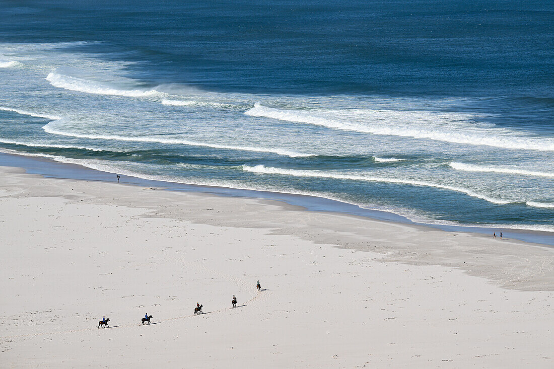 Reiter auf Pferden am Strand von Nordhoek, Western Cape, Südafrika