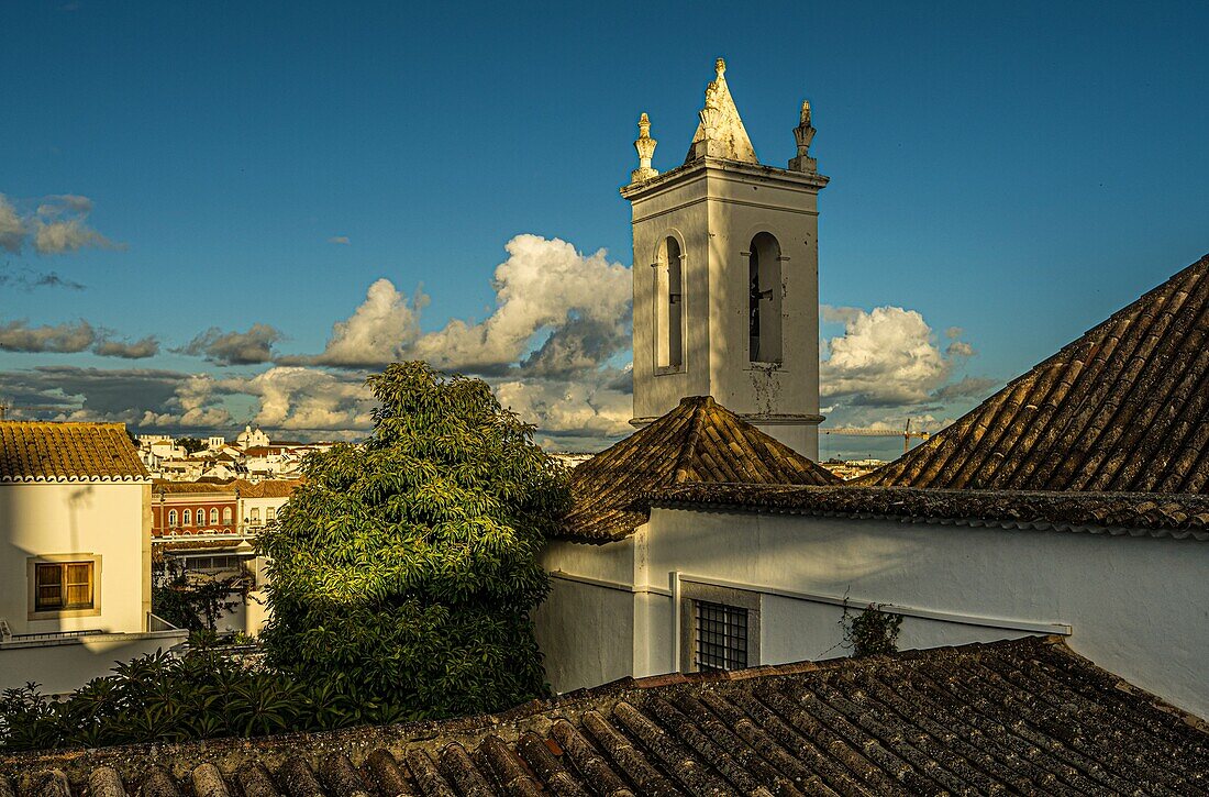 View over the roofs of historic houses in the old town of Tavira, tower of the Igreja da Misericórdia, Tavira, Algarve, Portugal