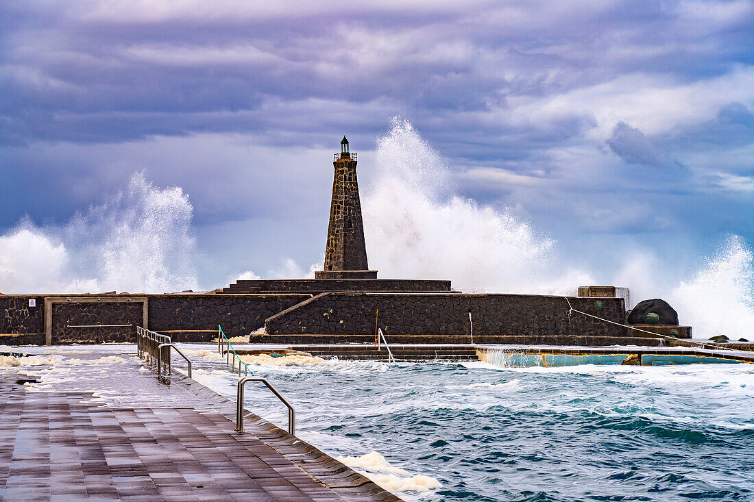 Surf at sea water swimming pool and lighthouse Faro de Bajamar, Bajamar, San Cristóbal de La Laguna, Tenerife, Canary Islands, Spain