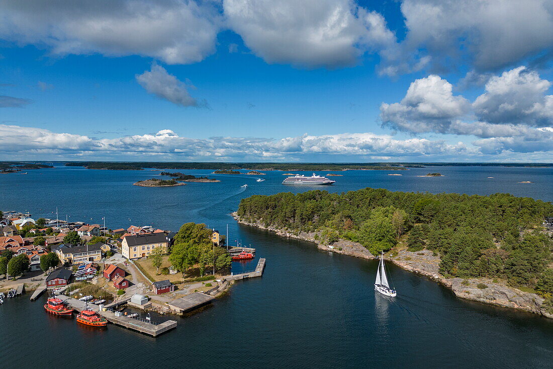 Luftaufnahme der Stadt mit Expeditionskreuzfahrtschiff World Voyager (nicko cruises) in der Ferne, Sandhamn, Stockholmer Schären, Schweden, Europa