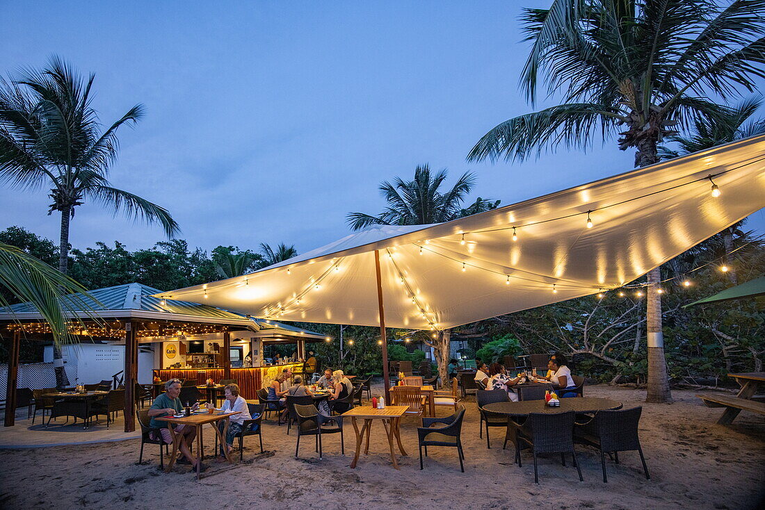 People enjoy dinner and drinks at the beach bar and restaurant at L'Anse Aux Epines Cottages, near Saint George's, Saint George, Grenada, Caribbean
