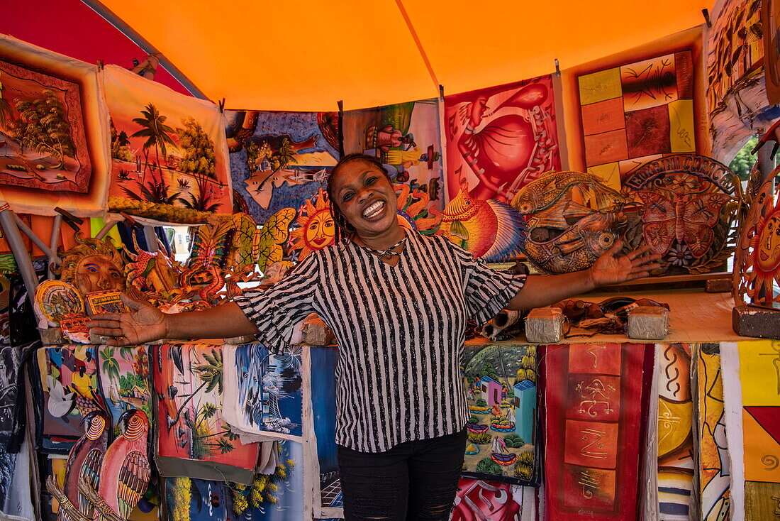 Freundliche Frau mit einladender Geste an einem Souvenirstand in Punda, Willemstad, Curaçao, Niederländische Antillen, Karibik