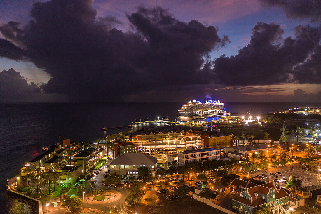 Luftaufnahme, Hafen von Otrabando mit dem Kreuzfahrtschiff Odyssey of the Seas (Royal Caribbean International), das nachts vom Pier abfährt, Willemstad, Curaçao, Niederländische Antillen, Karibik