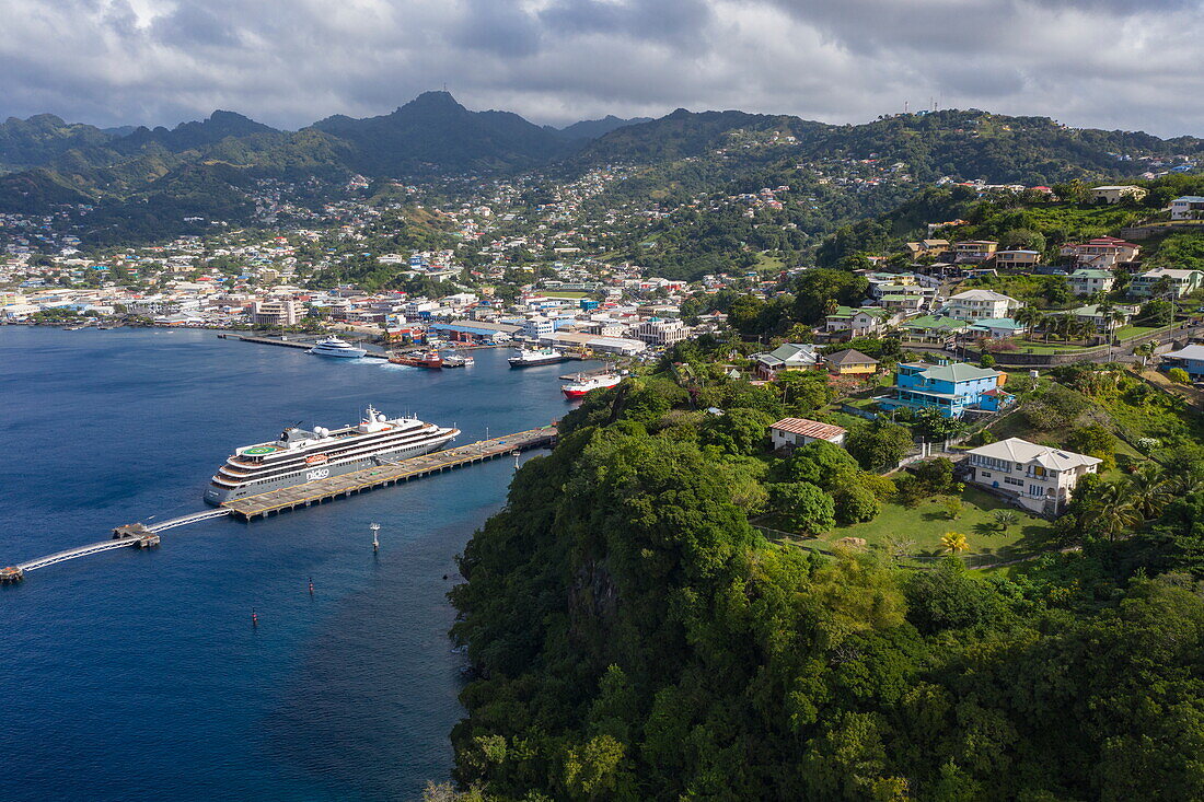 Aerial view of cliff top houses and expedition cruise ship World Voyager (nicko cruises) at pier with city beyond, Kingstown, Saint George, St Vincent Island, Saint Vincent and the Grenadines, Caribbean