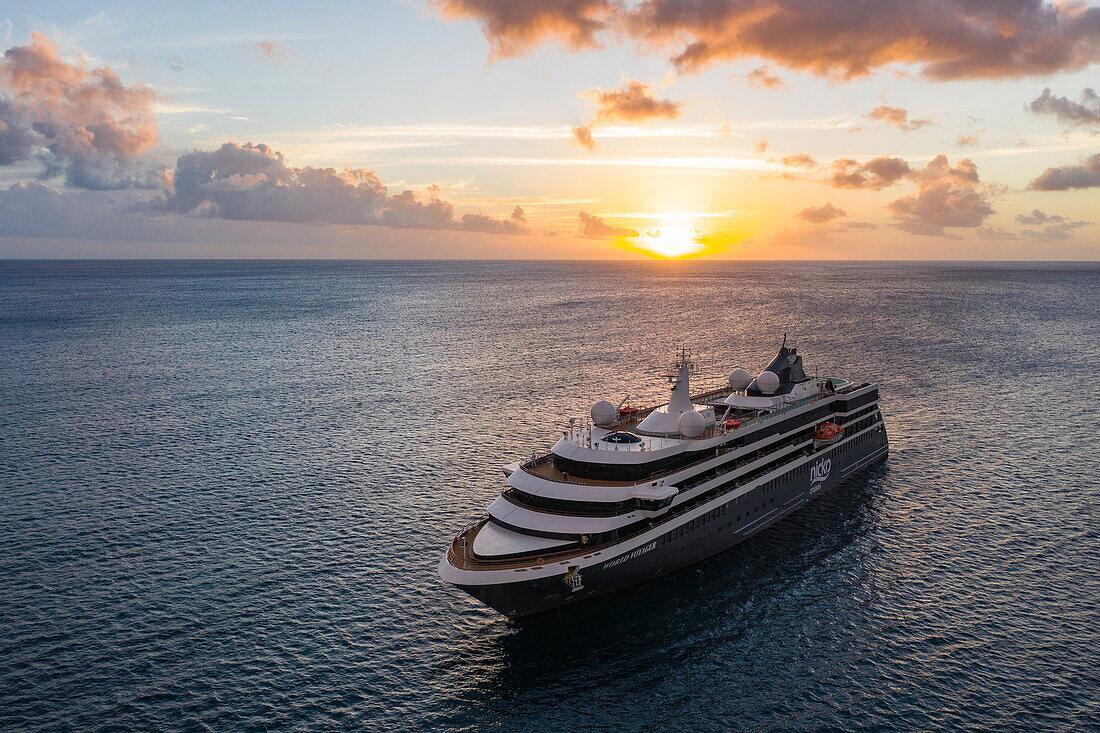 Luftaufnahme von Expeditionskreuzfahrtschiff World Voyager (nicko cruises) bei Sonnenuntergang, in der Nähe der Insel Nevis, St. Kitts und Nevis, Karibik