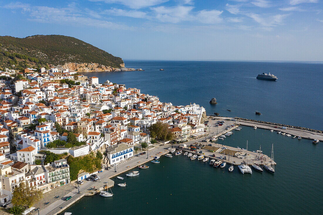 Aerial view of the town with expedition cruise ship World Explorer (nicko cruises) behind, Skopelos, Thessaly, Greece, Europe