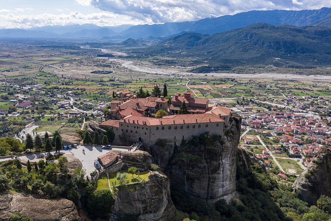 Aerial view of Saint Stephen's Monastery (Agios Stefanos) at Meteora with town, riverbed in valley and mountains behind, Kastraki, Thessaly, Greece, Europe