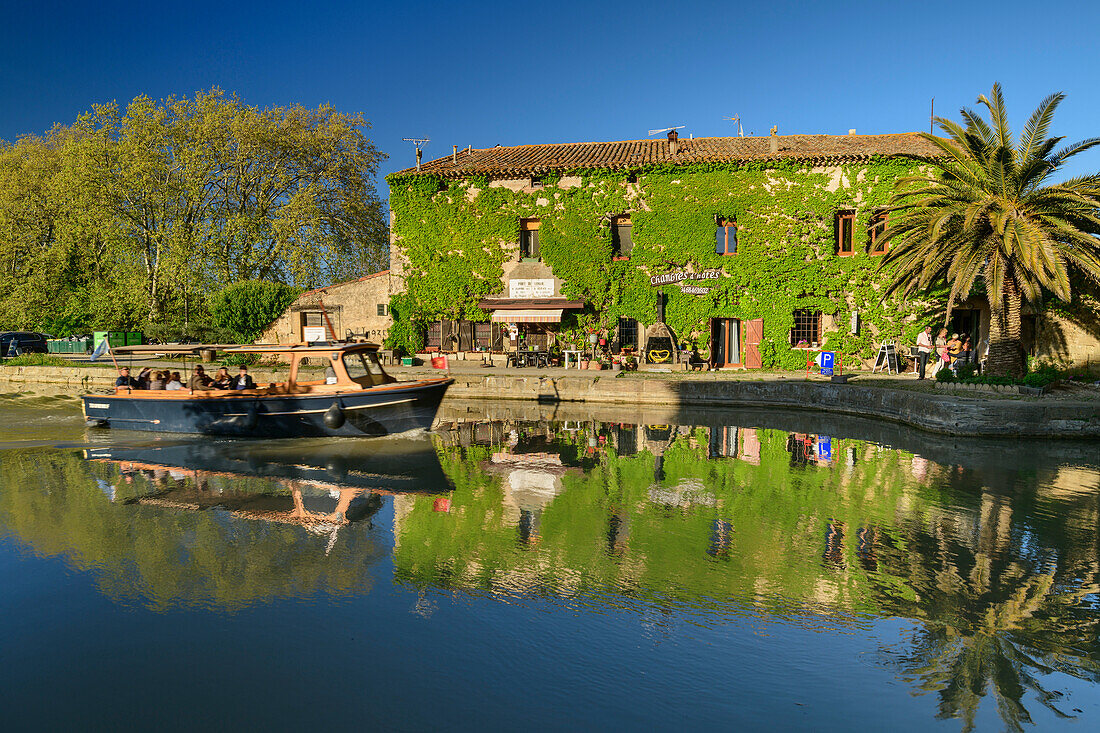 Boat travels on Canal du Midi, Le Somail in the background, Le Somail, Canal du Midi, UNESCO World Heritage Canal du Midi, Occitania, France