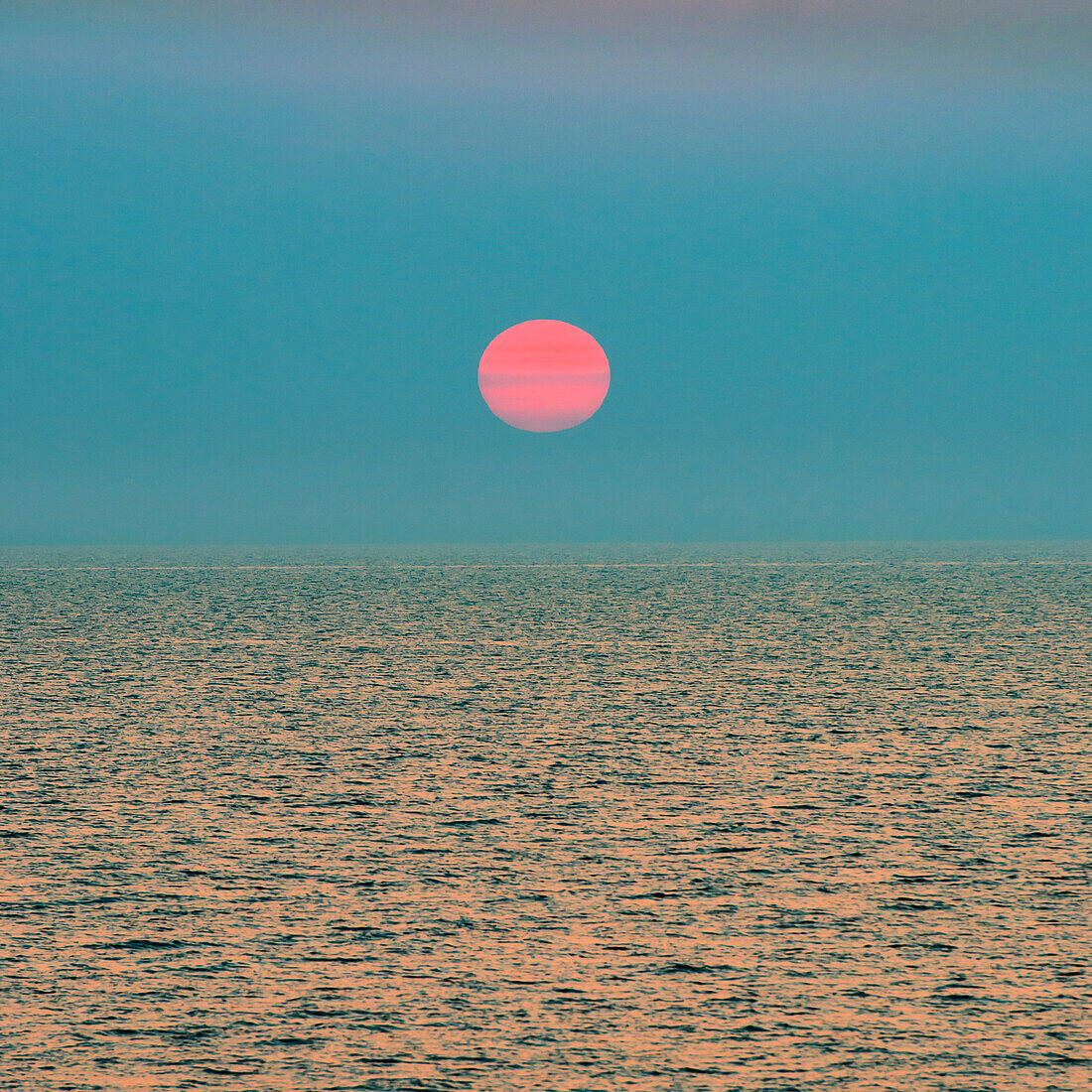 Red setting sun over ocean