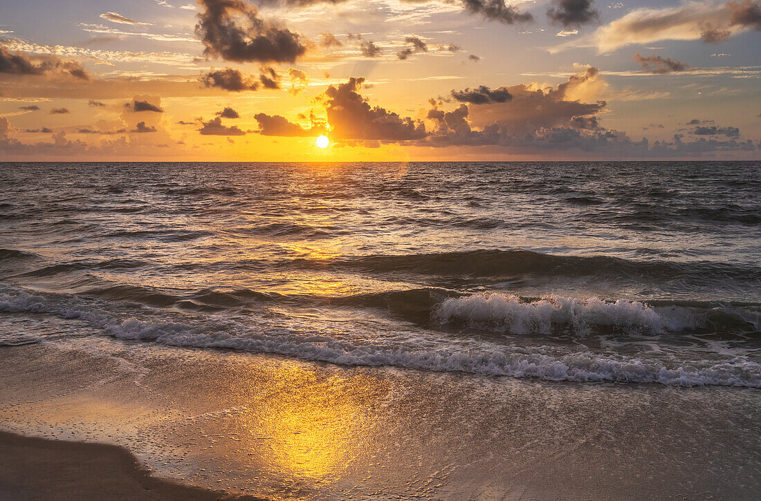 Meereswellen waschen den Strand bei Sonnenaufgang