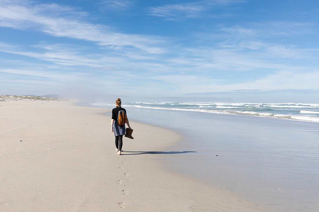 South Africa, Hermanus, Teenage girl (16-17) walking along Grotto Beach