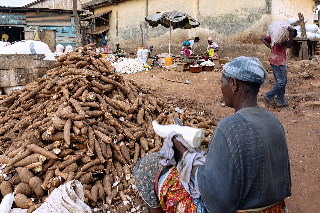 Women processing cassava at the market in Techiman in the Bono East region of northern Ghana in West Africa