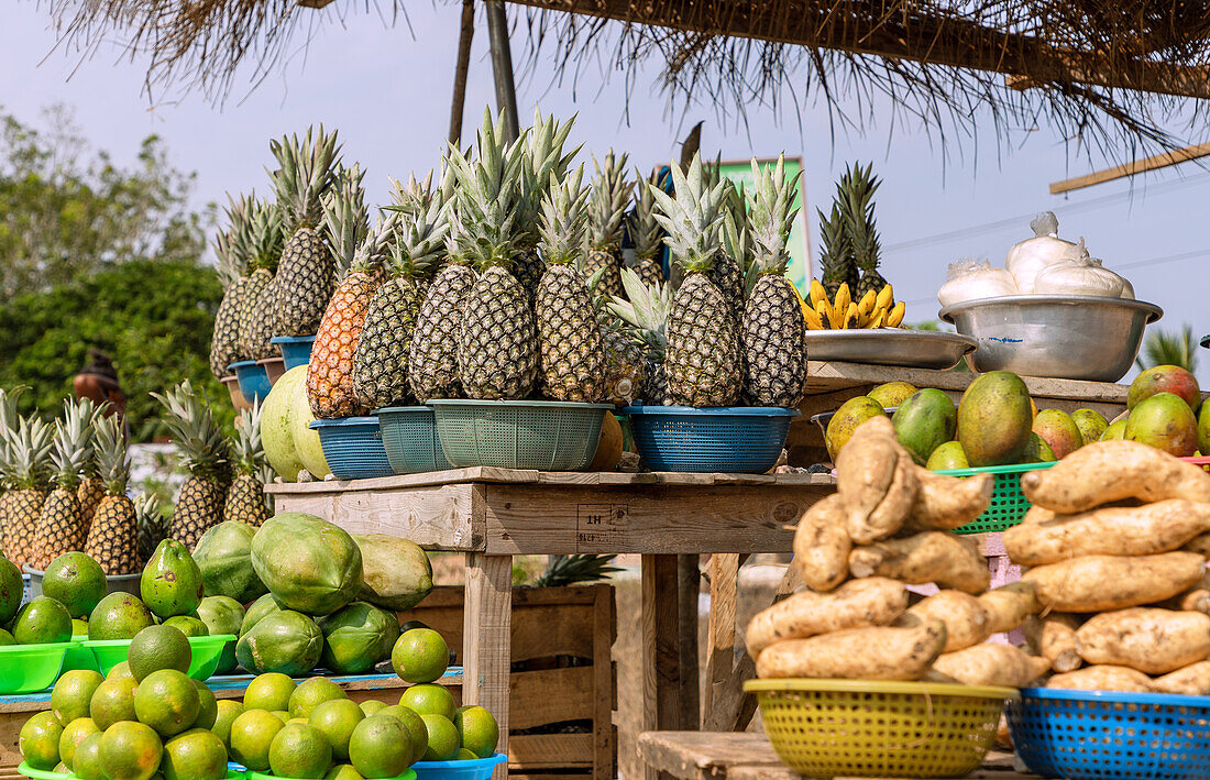 Street sale of limes, papayas, mangoes, pineapples, avocados and sweet potatoes in Winneba in the Central Region of western Ghana in West Africa