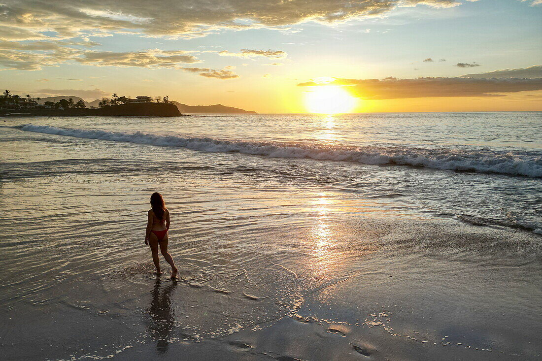 Aerial view of woman walking on Flamingo Beach at sunset, Playa Flamingo, Guanacaste, Costa Rica, Central America
