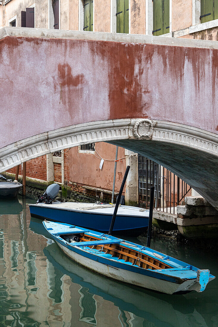 Ein kleines Boot im Rio und unter einer Brücke. Venedig, Venetien, Italien