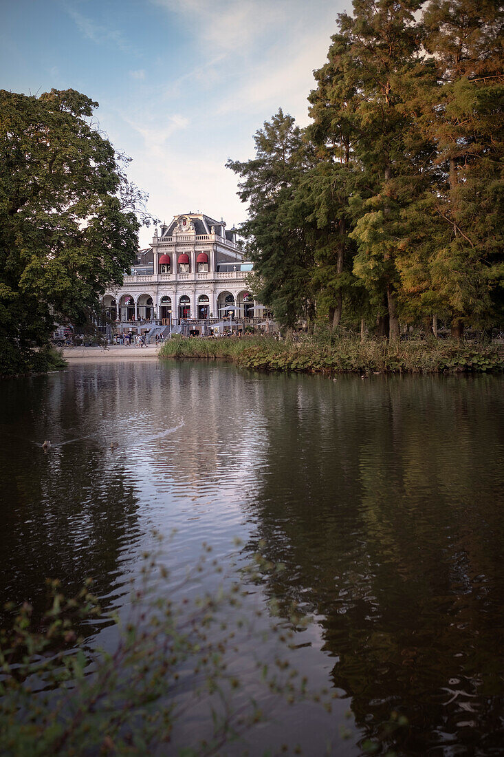 Blick über Gewässer des Vondelpark zum historischem Gebäude, Amsterdam, Provinz Noord-Holland, Niederlande, Europa