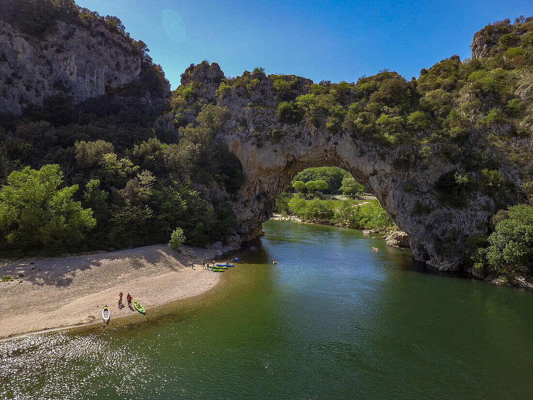 Aerial view from the rock arch Pont Arch in the Gorges de L'ardeche with canoes and sandbank of the Ardeche river, Labastide-de-Virac, Ardèche, Auvergne-Rhône-Alpes, France, Europe