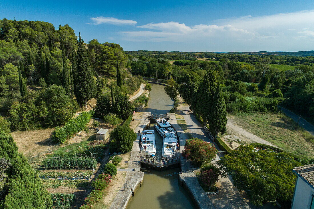 Luftaufnahme von einem Le Boat Horizon 5 Hausboot und anderer Hausboote in der Schleuse Écluse de Pechlaurieron am Canal du Midi, Argens-Minervois, Aude, Okzitanien, Frankreich, Europa