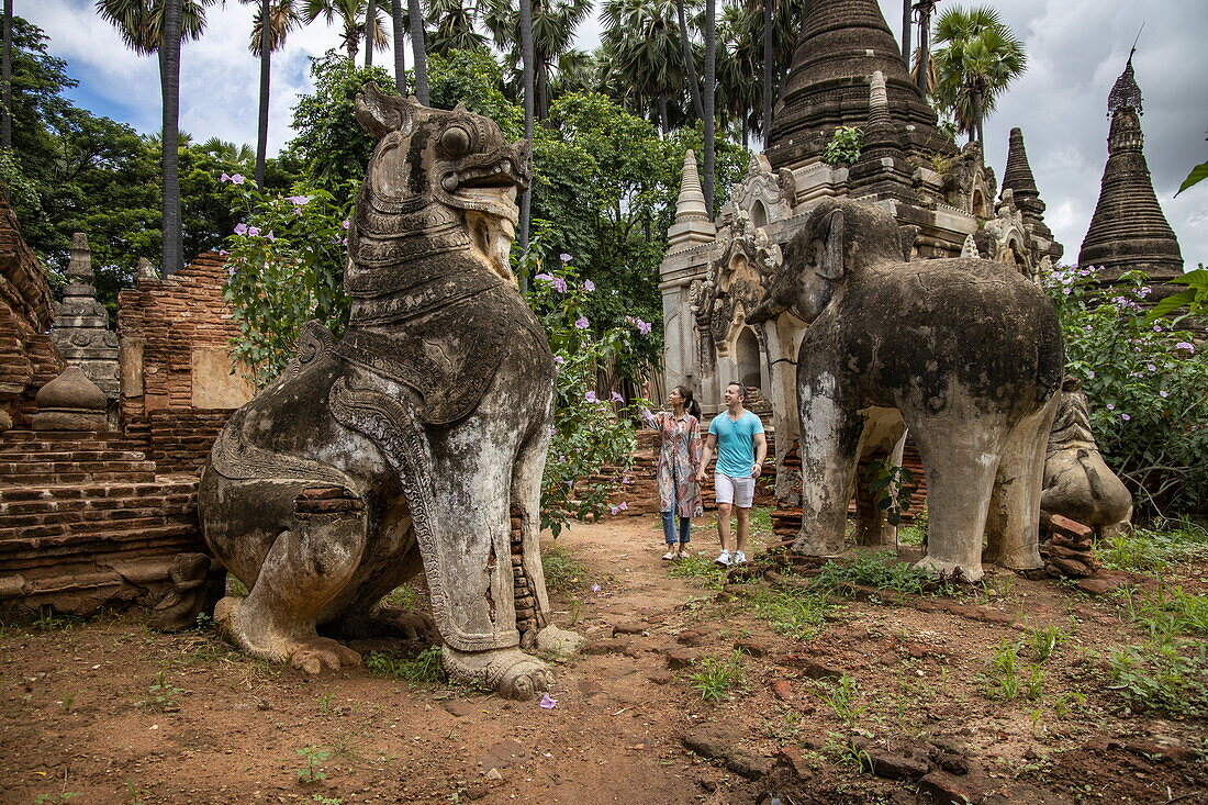 Couple strolling through area of ancient statues and pagodas dating from AD 11-13, A Myint Village, Chaung-U, Sagaing Region, Myanmar, Asia
