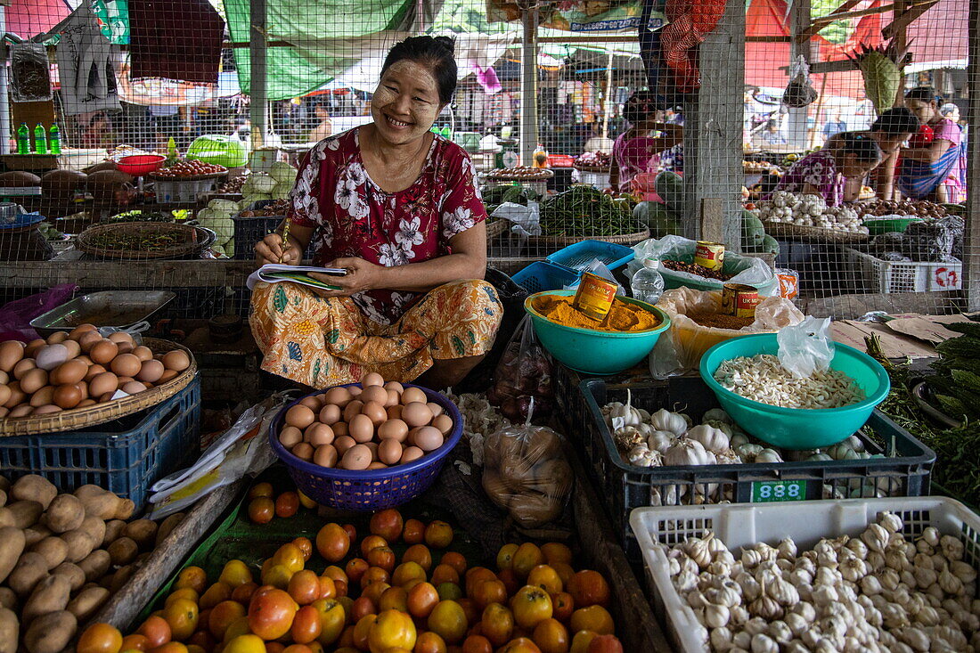 Fröhliche Obst- und Gemüseverkäuferin auf dem lokalen Markt, Mawlaik Township, Region Sagaing, Myanmar, Asien