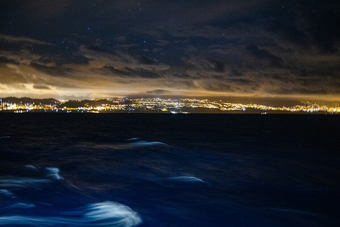 Atlantic Ocean and city lights at night, at sea, near Tenerife, Canary Islands, Spain, Europe