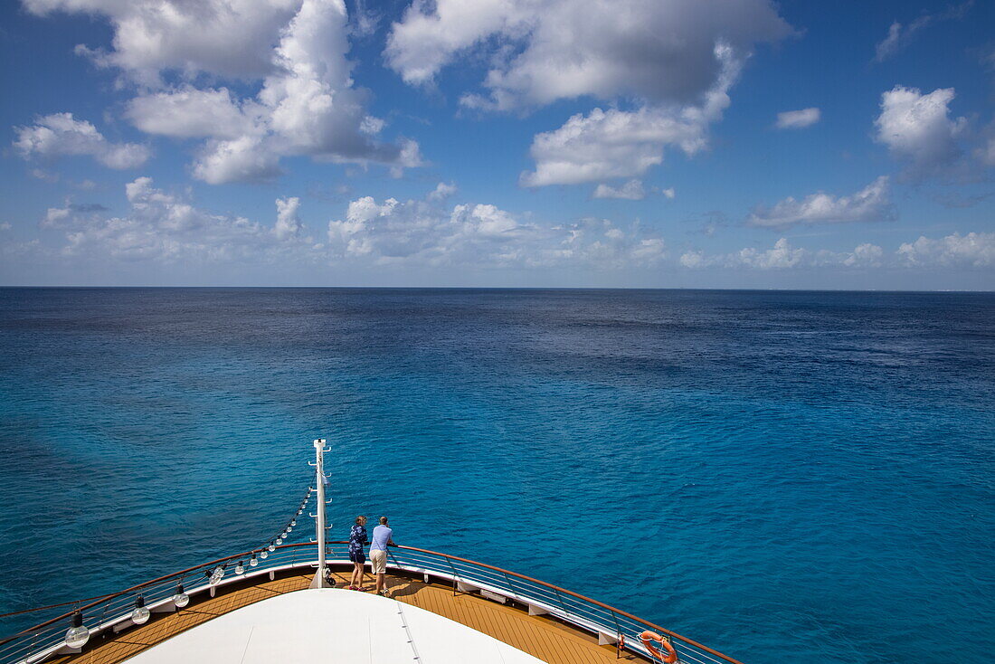 Couple on bow of expedition cruise ship World Voyager (nicko cruises) with Caribbean sea water in fifty shades of blue, San Miguel de Cozumel, Cozumel Island, Quintana Roo, Mexico, Caribbean