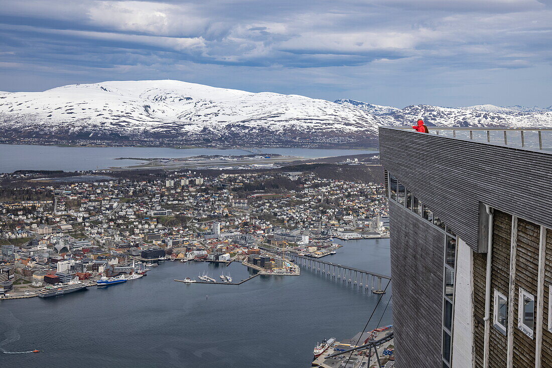 Blick auf die Stadt und die schneebedeckten Berge vom Berg Storsteinen mit dem Expeditionskreuzfahrtschiff World Voyager (nicko cruises) am Pier, Tromsø, Troms og Finnmark, Norwegen, Europa