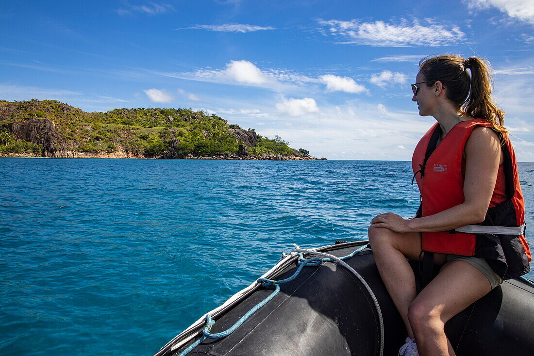 Junge Frau während des Transfers mit dem Zodiac Schlauchboot vom Boutique-Kreuzfahrtschiff M/Y Pegasos (Variety Cruises), Insel Curieuse, Seychellen, Indischer Ozean