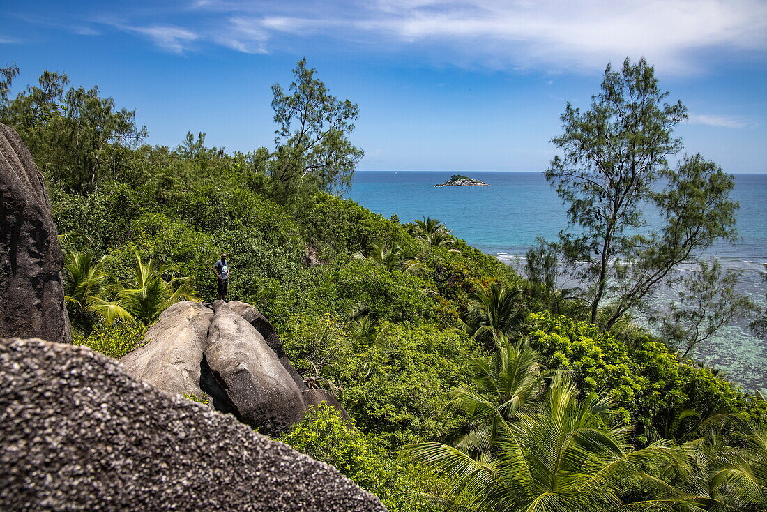 Ranger Guide steht auf Granitfelsen, Moyenne Island, St. Anne Marine National Park, in der Nähe der Insel Mahé, Seychellen, Indischer Ozean