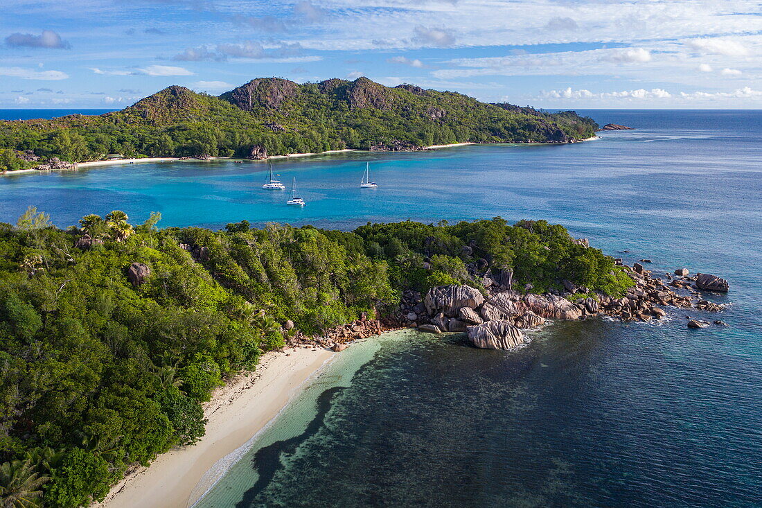Aerial view of Anse St. Jose beach with sailing boats in Baie Laraie bay in the distance, Curieuse island, Seychelles, Indian Ocean