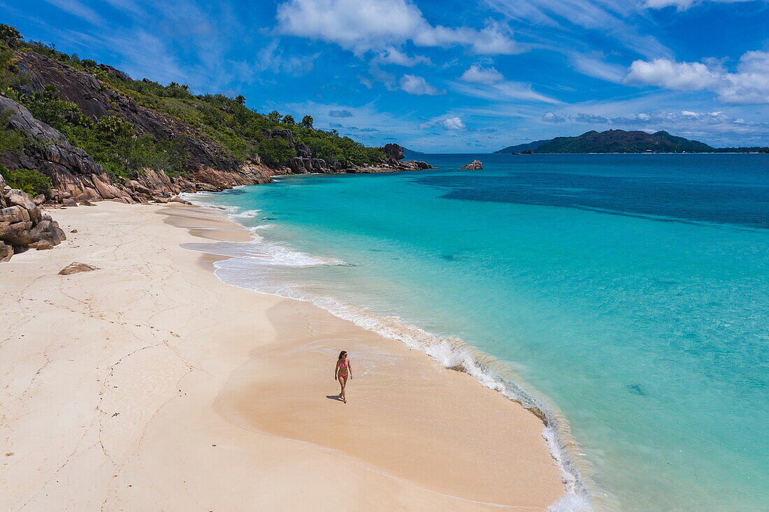Luftaufnahme, junge Frau, die am Strand von Anse St. Jose spaziert, Insel Curieuse, Seychellen, Indischer Ozean