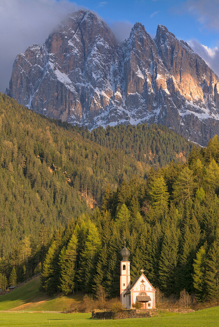 Die Kirche St. Magdalena im Villnösstal, im Hintergrund die Dolomiten, Gipfel der Geislerspitzen, Südtirol, Italien.