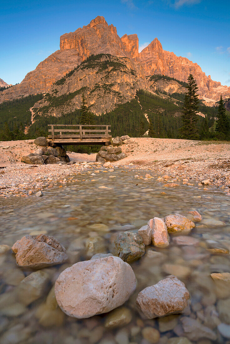 Small stream in the Dolomites in reddish evening light, South Tyrol, Italy.