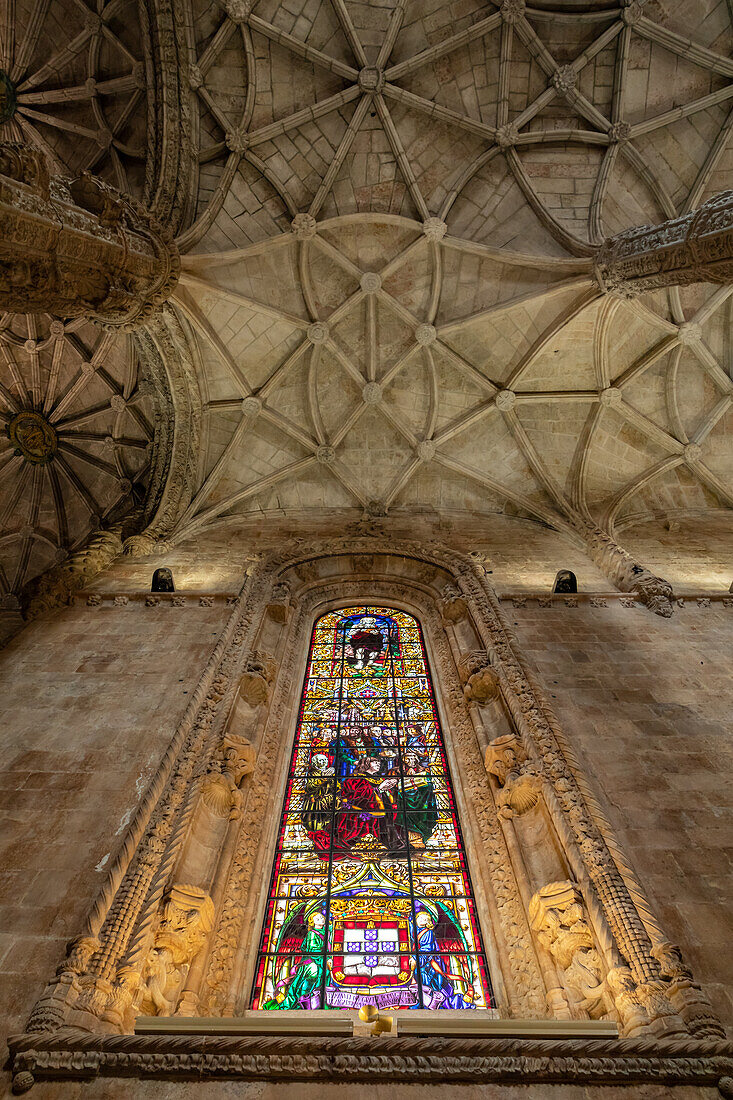 Blick nach oben auf die Gewölbedecke und farbig bemalten  Glasfenster der Klosterkirche Hieronymus-Kloster in Belem, Lissabon, Portugal