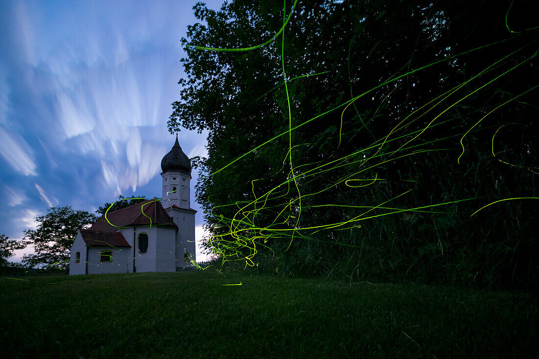 Glühwürmchen-Leuchtspuren am Waldrand mit Kapelle (Lamprohiza splendidula), Glühwürmchen, Penzberg, Oberbayern, Deutschland