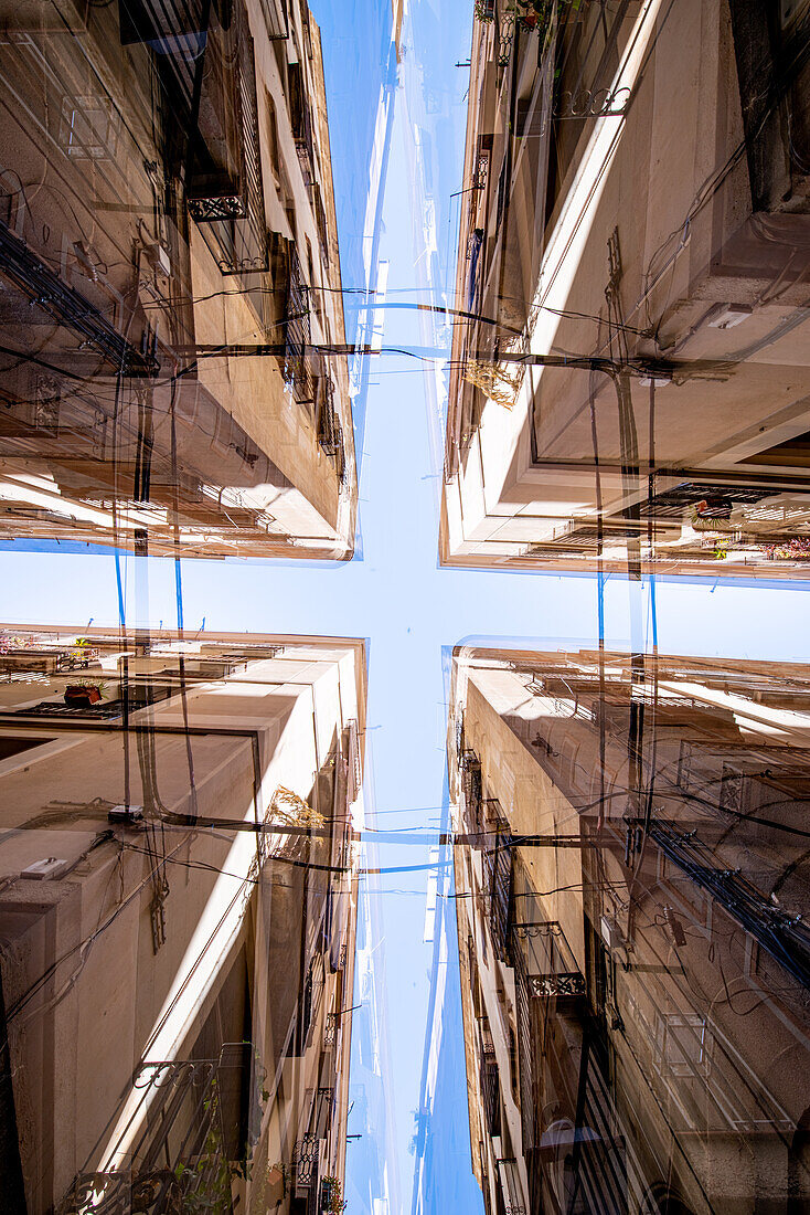 Looking up between walls of Barcelona's narrow downtown streets, Spain.