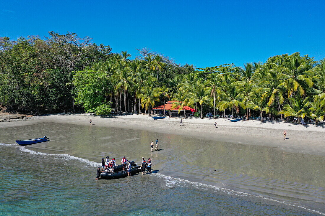 Aerial view of Zodiac inflatable boat landing on beach for passengers from expedition cruise ship World Voyager, Isla Parida, Paridas Islands, Gulf of Chiriqui, Panama, Central America