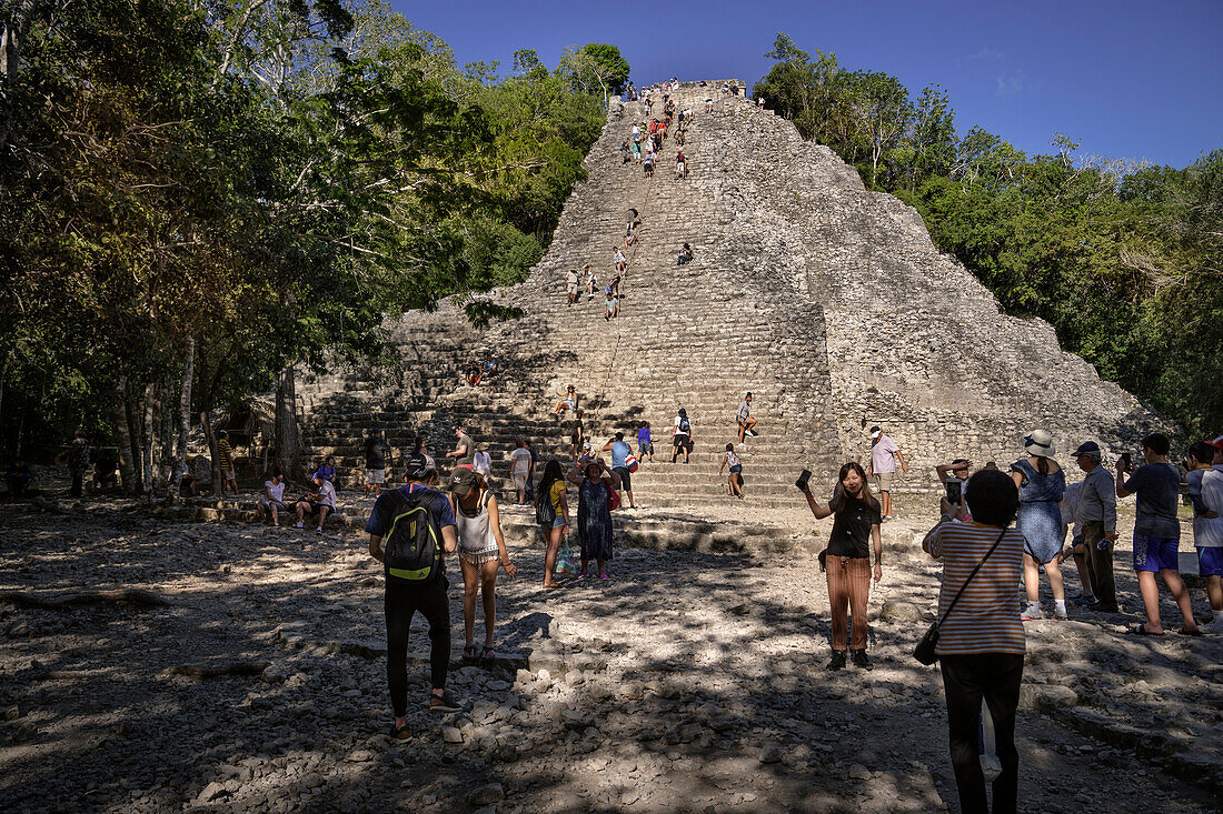 Visitors photograph themselves in front of the ruins of the Nohoch Mul pyramid in the Mayan ruins of Cobá, Yucatán, Mexico, North America, Latin America