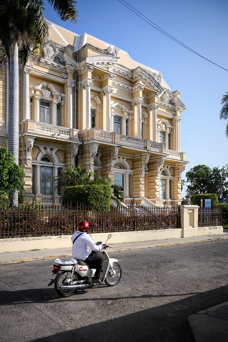 Man on a motorcycle drives past the &quot;Museo de Antropología e Historia&quot; museum, Mérida, capital of Yucatán, Mexico, North America, Latin America