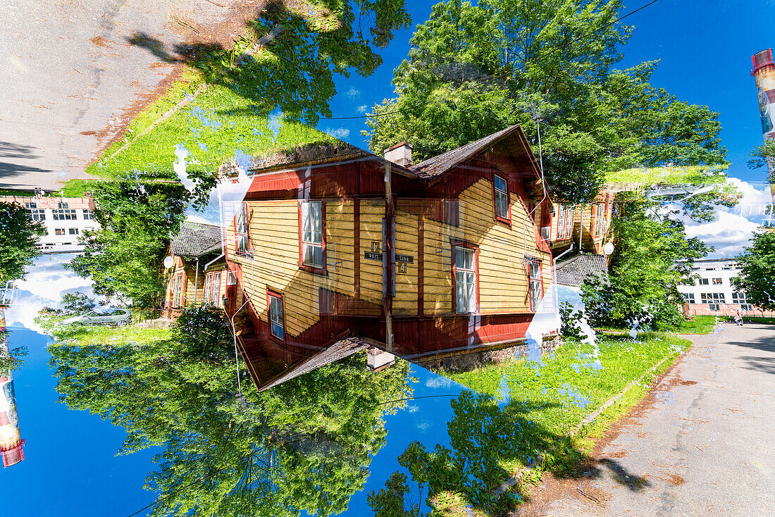 Doppelbelichtung eines gelben Wohngebäudes aus Holz in grüner Umgebung in Tartu, Estland