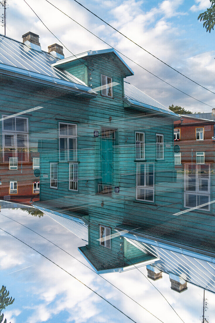 Farbenfrohe Doppelbelichtung von mit Holz verkleideten Häusern in Tartu, Estland