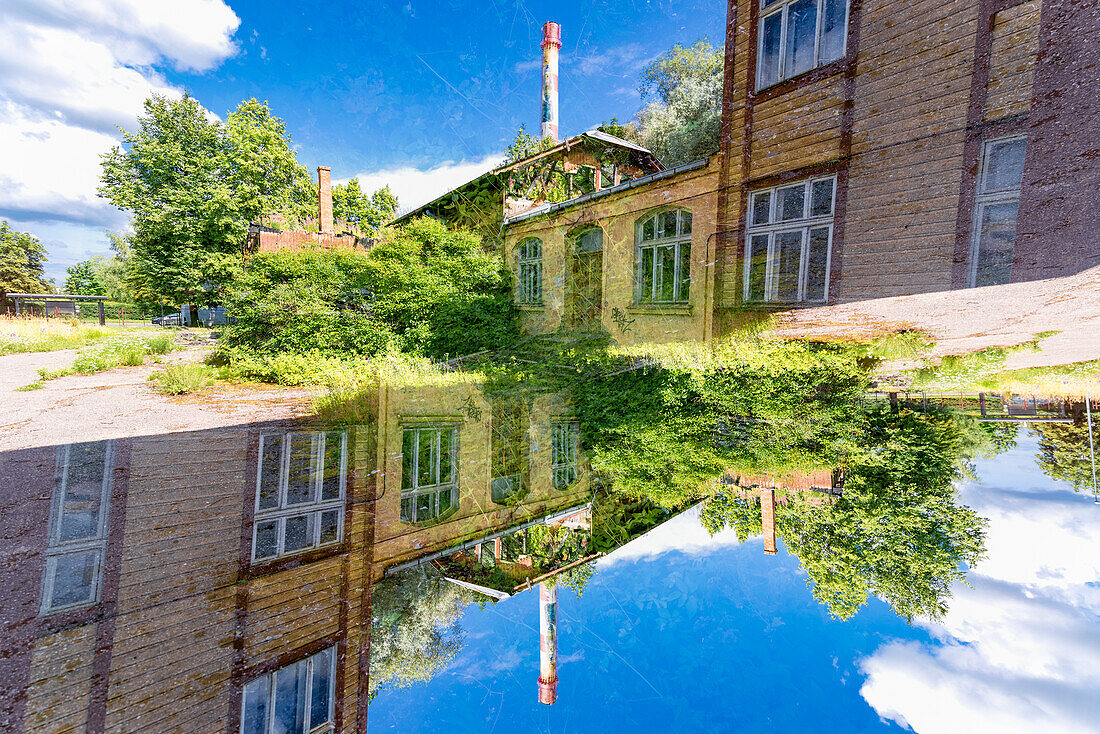 Doppelbelichtung einer heruntergekommenen Fabrik in grüner Umgebung in Tartu, Estland