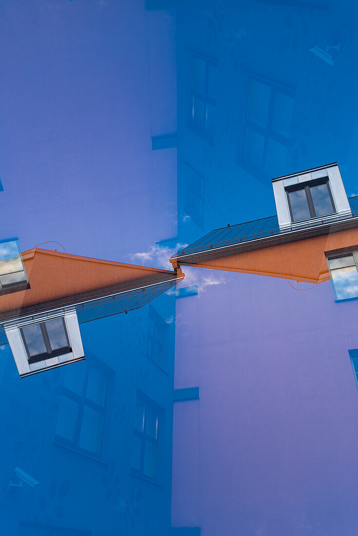 Double exposure of a orange residential building against a clear blue sky in Tartu, Estonia.