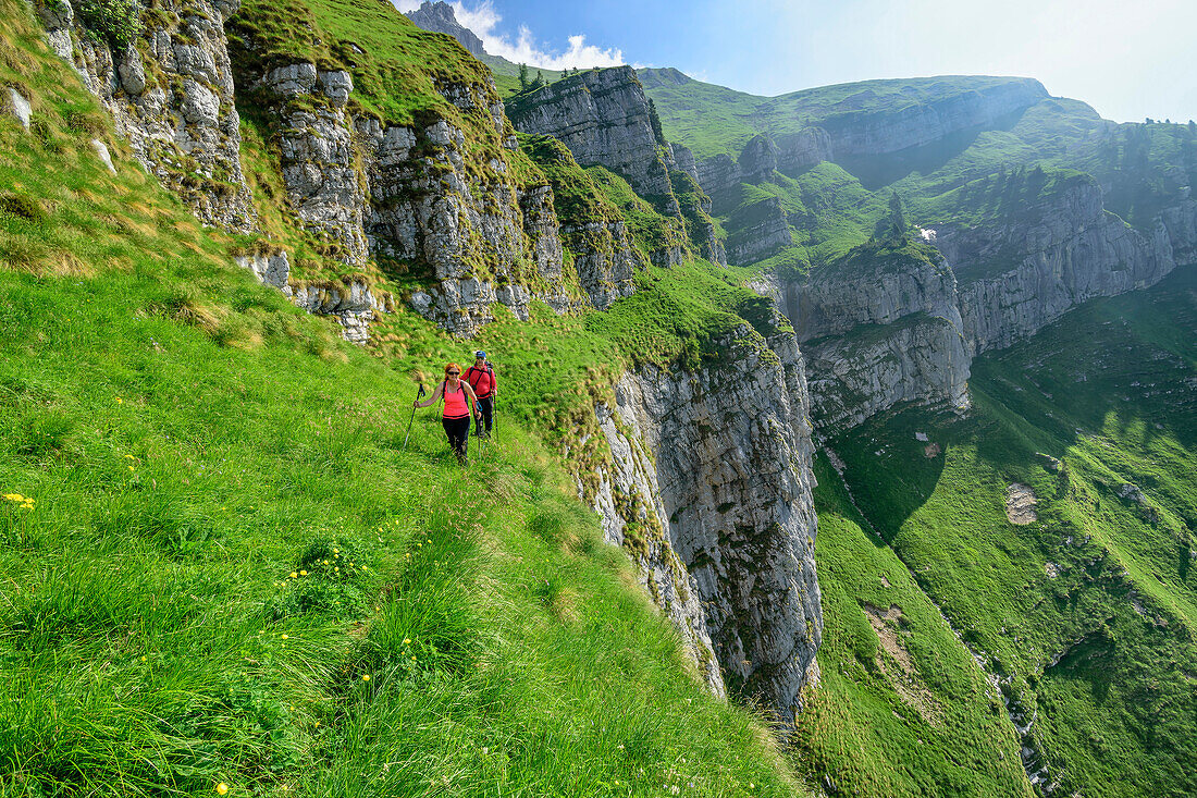 Zwei Personen wandern durch steile Grasflanke, Feltriner Berge, Belluneser Höhenweg, Dolomiten, Venezien, Venetien, Italien