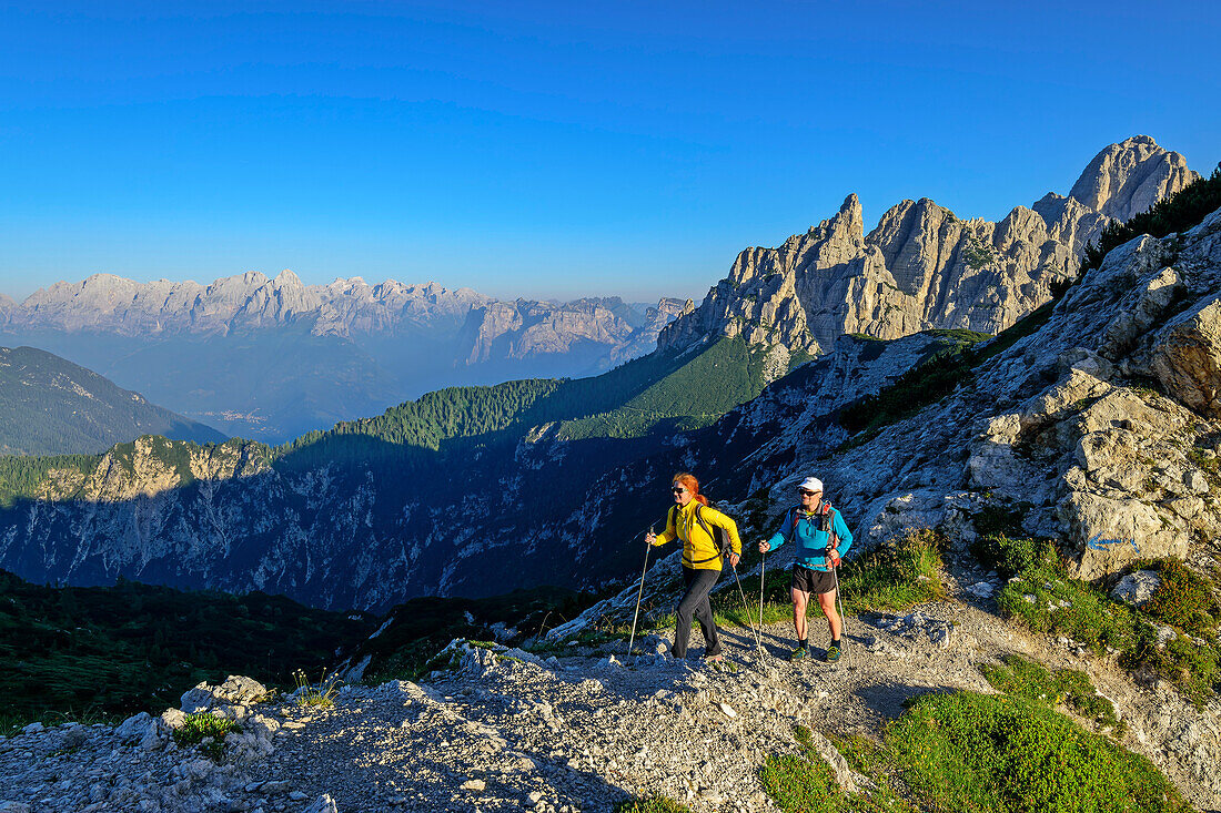 Man and woman hiking on hiking trail on mountain ridge, Forcella di Zita, Belluneser Höhenweg, Dolomites, Veneto, Venetia, Italy