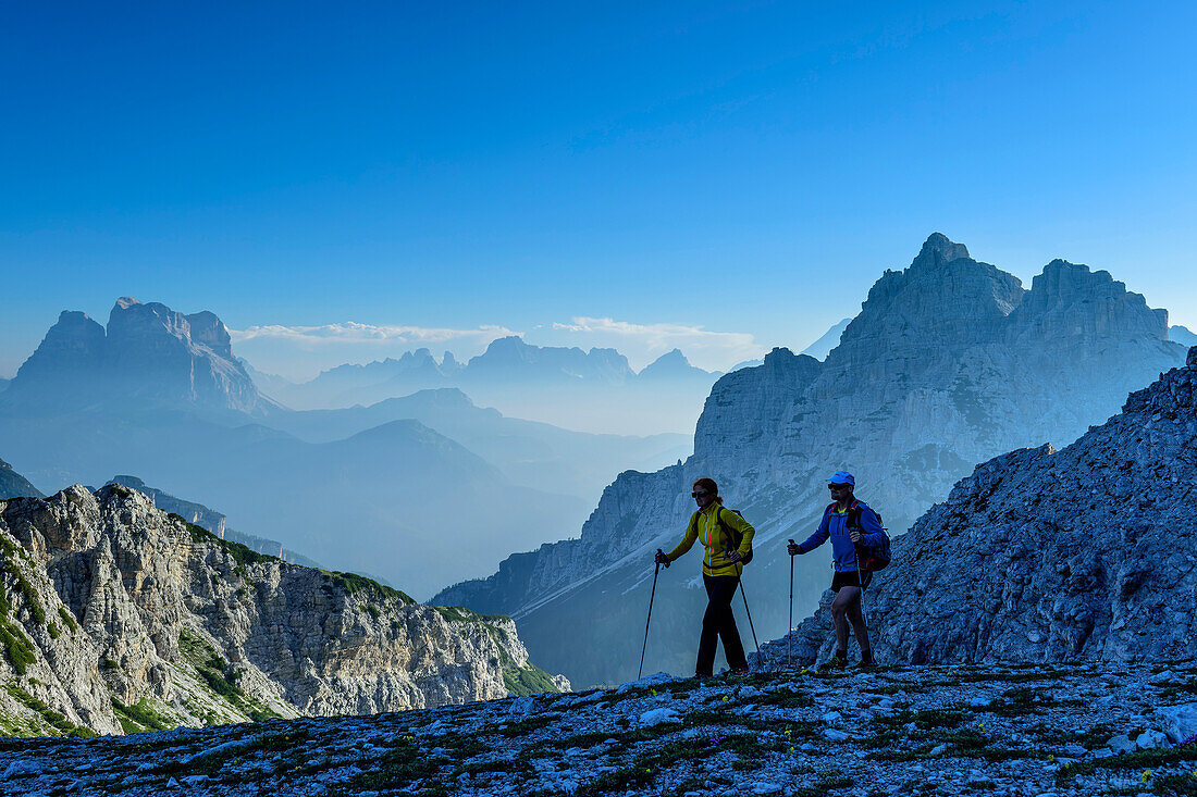 Mann und Frau beim Wandern mit Monte Pelmo und Cima di Pramper im Hintergrund, Belluneser Höhenweg, Dolomiten, Venezien, Venetien, Italien