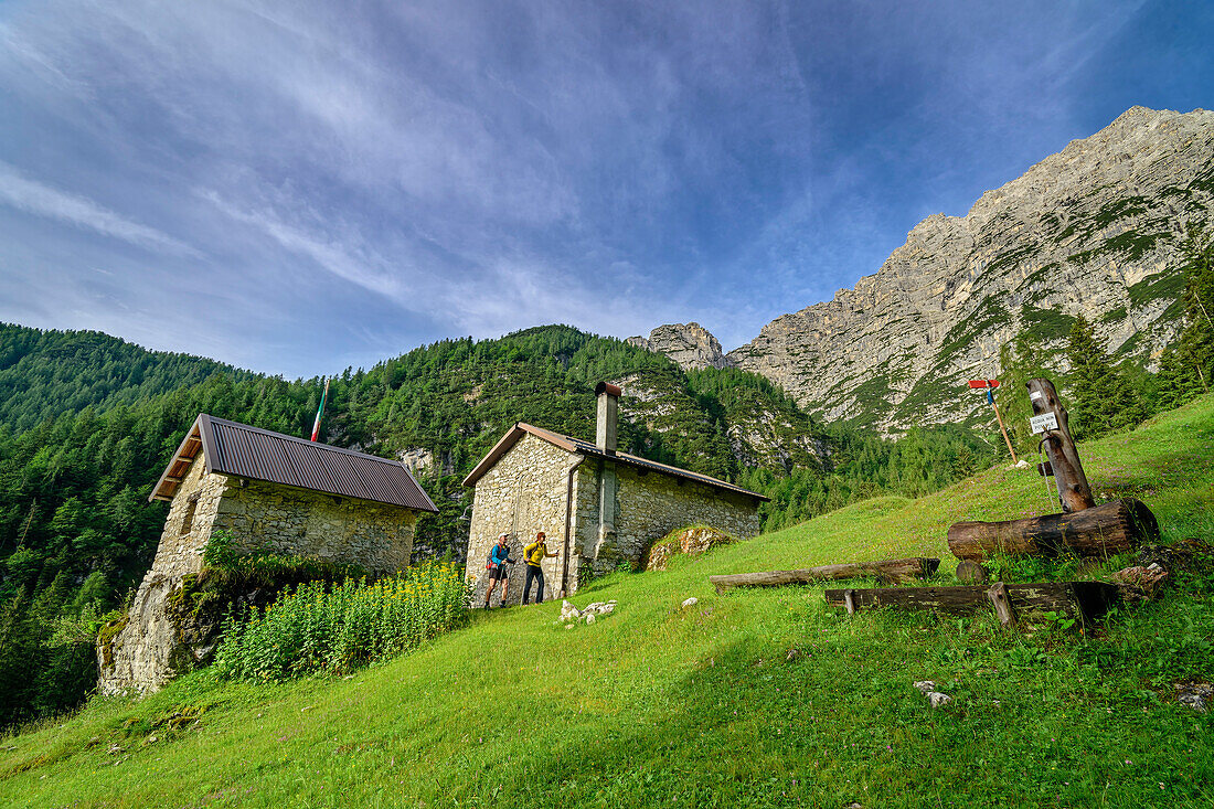 Mann und Frau beim Wandern an der Almhütte Casera Valbona, Bosconero-Gruppe, Dolomiten, Venezien, Venetien, Italien