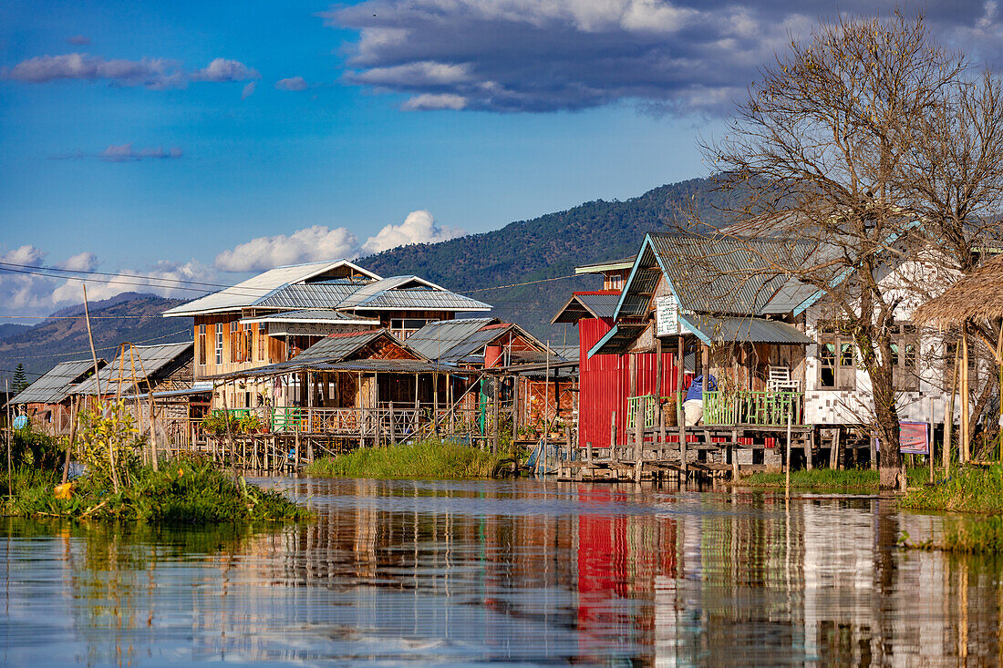 Colorful houses on stilts along the waterway through the town of Nang Pang in the shallow Inle Lake in Myanmar, Asia